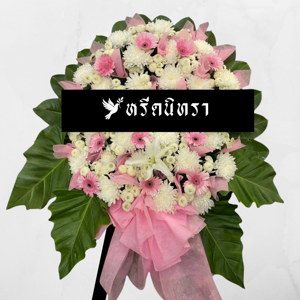 พวงหรีดดอกไม้สดโทนสีชมพูขาว ดีไซน์หวานสุภาพ ตกแต่งด้วยดอกเยอบีร่า ลิลลี่ และเบญจมาศ พร้อมผ้าโปร่งสีชมพู ดูอ่อนโยนและเรียบหรู