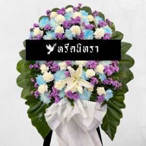พวงหรีดดอกไม้สดโทนฟ้าม่วงขาว ดีไซน์สดใสสุภาพ ตกแต่งด้วยดอกเบญจมาศ คาร์เนชั่น สแตติส และลิลลี่ พร้อมใบไม้สีเขียวขนาดใหญ่