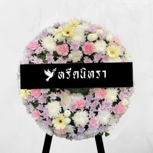 พวงหรีดดอกไม้สดโทนชมพูขาว ดีไซน์ทรงกลมเรียบหรู ตกแต่งด้วยดอกเบญจมาศ คาร์เนชั่น เยอบีร่า และหน้าวัว ให้ความรู้สึกอ่อนโยนและสุภาพ