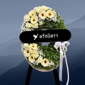 พวงหรีดดอกไม้สดโทนขาวครีมเขียว ดีไซน์โมเดิร์นทรงวงรี ตกแต่งด้วยดอกกุหลาบ เยอบีร่า และยิปโซ ให้ความรู้สึกสุภาพ เรียบหรู และอบอุ่น
