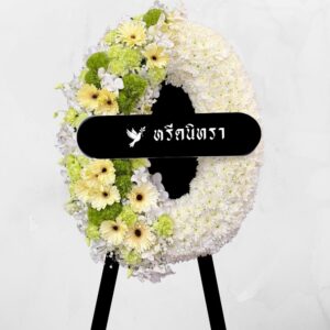พวงหรีดดอกไม้สดโทนขาวเขียว ดีไซน์โมเดิร์นเรียบหรู ตกแต่งด้วยดอกเยอบีร่า เบญจมาศ คาร์เนชั่น และกล้วยไม้สีขาว ให้ความรู้สึกสุภาพและสง่างาม